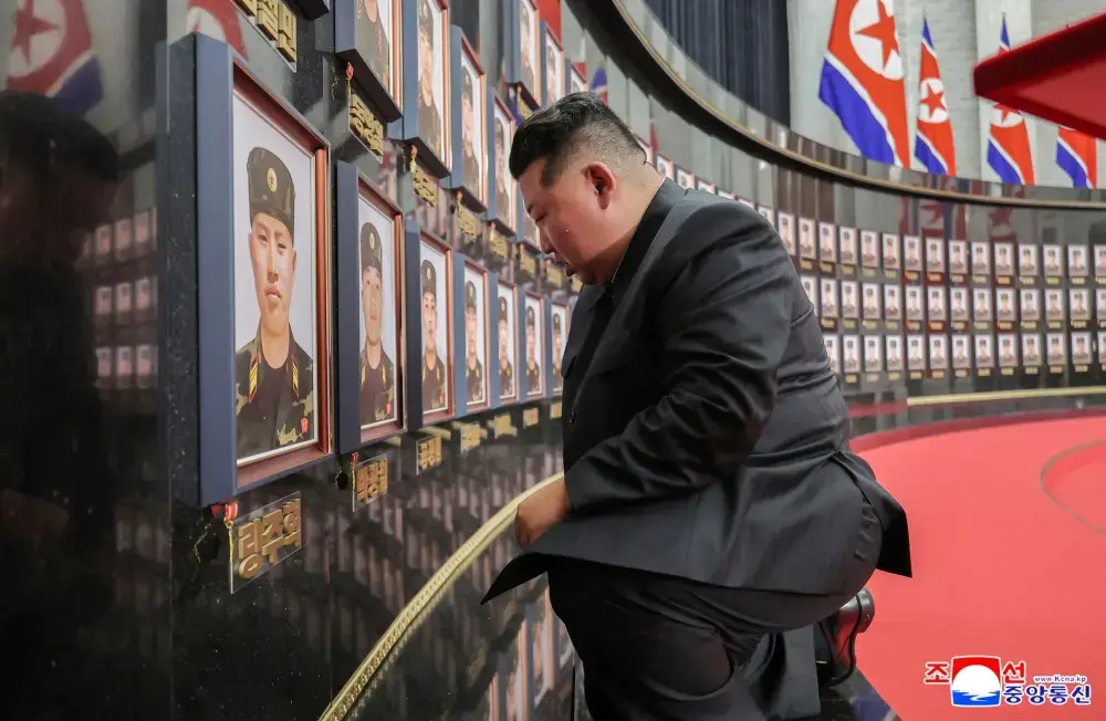 金正恩在国家授勋仪式上为阵亡官兵遗像挂上“共和国英雄”称号勋章。图/朝中社